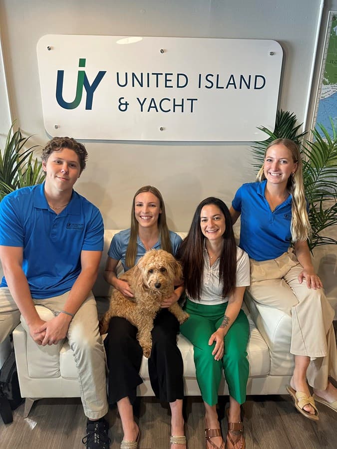 UIY office team beneath the United Island & Yacht sign